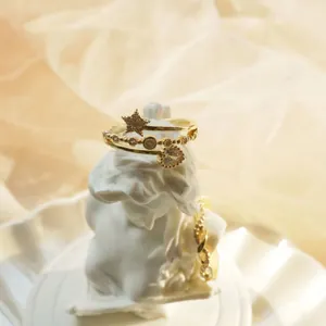 Close-up of elegant gold heart and star rings displayed on a white classical plaster bust