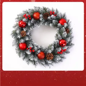 Detailed view of a snow-dusted Christmas wreath featuring red baubles, berries and pinecones