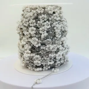 Detailed view of handmade white pearl flower chain on spool for DIY jewelry projects