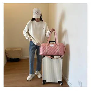 Large capacity pink quilted travel bag shown attached to a white suitcase handle
