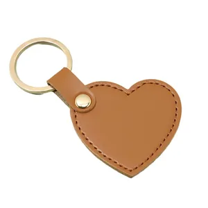 Minimalist brown heart-shaped leather keychain with gold-tone metal ring and stitching.