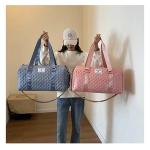 Asian model showcasing large grey and pink quilted travel bags for gym and short trips