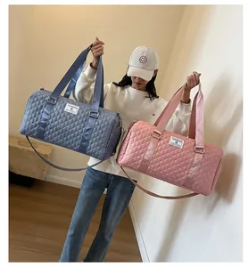Model holding blue and pink quilted travel duffle bags for fitness or short trips