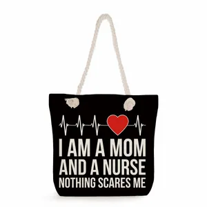Close-up of black canvas tote bag with Mom and Nurse heart monitor print design.