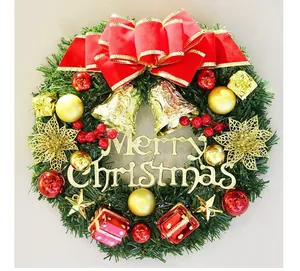 Detailed view of a festive Christmas wreath with red bow and golden Merry Christmas sign.