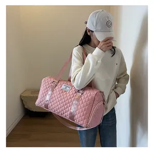 Model carrying a large capacity pink quilted travel bag in a stylish lifestyle setting