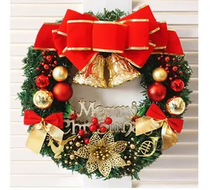 Detailed close-up of a festive Christmas wreath decorated with red bows and gold bells.