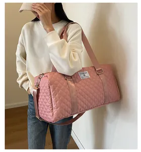 Fashionable woman carrying a large pink quilted travel bag for gym and short weekend trips