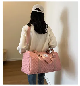 Large pink quilted travel bag carried on shoulder showing its capacity and style.