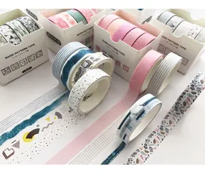 Close-up of various patterned washi tape rolls and boxed sets on a white surface.