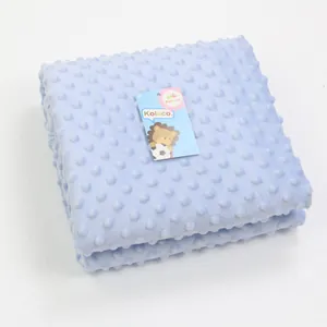 Folded light blue minky baby blanket with textured dot pattern and Kolaco brand tag