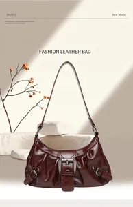 Detailed view of brown pleated leather underarm bag with decorative metal buckle