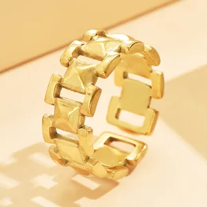 Close-up of minimalist gold chain link hollow ring with modern metallic texture