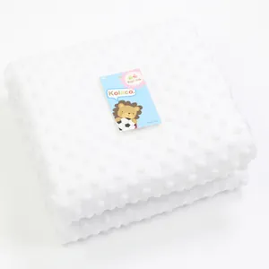 Close-up of soft white minky bubble baby blanket with textured dot pattern.