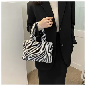 Fashionable plush zebra print handbag styled with a professional black blazer for women