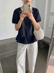 Vista dettagliata della borsa a secchiello in macramè bianco intrecciato con outfit estivo