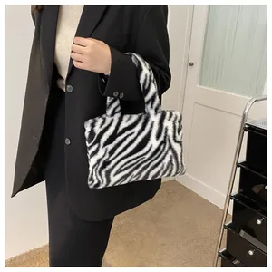 Close-up of a small plush handbag with a black and white zebra pattern design.