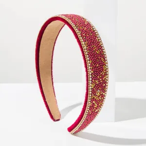 Macro detail of Baroque red velvet headband embellished with gold rhinestones and beads.