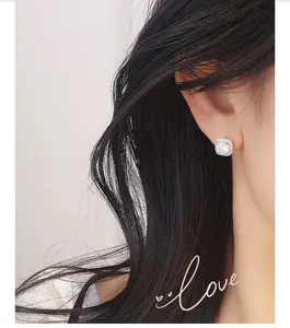 Detailed close-up of a s925 silver moissanite square stud earring worn on model's ear