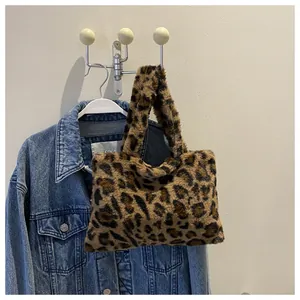 Trendy leopard print plush handbag hanging on a denim jacket in a lifestyle setting