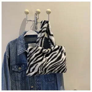 Zebra print plush handbag displayed hanging next to a denim jacket on a wall hook