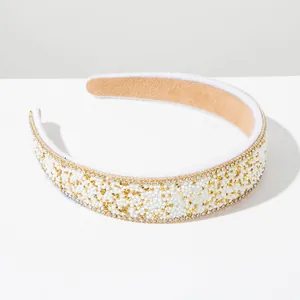 Close-up of Baroque style wide headband with white beads and golden rhinestones
