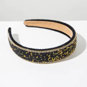 Detail view of a vintage Baroque wide headband with black velvet and gold rhinestones.