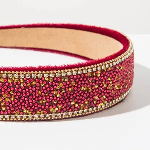 Detail close-up of a red baroque headband featuring dense beads and sparkling crystals