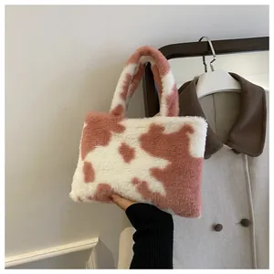 Close-up of a pink and white cow print plush handbag showing its soft texture