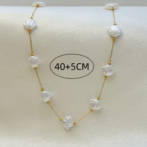 Detail of gold chain necklace with elegant white seashell charms and 40+5cm length mark.