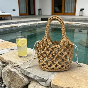 Borsa a mano in paglia intrecciata a macramè a bordo piscina per un look estivo.