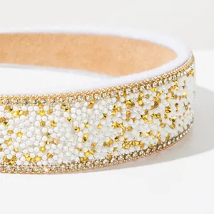 Detailed close-up of Baroque wide headband with glittering rhinestones and white pearls