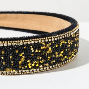 Macro detail shot of a vintage baroque headband with black beads and gold rhinestones.