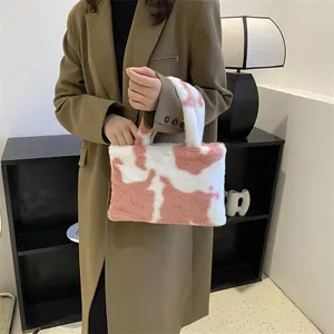 Stylish soft plush handbag featuring a pink and white cow print pattern for women
