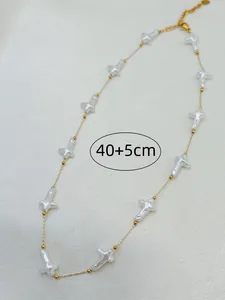 Elegant shell cross necklace detail showing 40+5cm length on textured background.