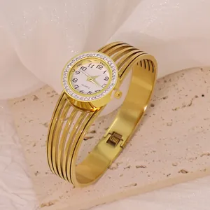 Close-up of elegant gold stainless steel bangle watch with rhinestone bezel