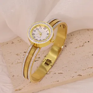 Detailed view of elegant gold-toned bangle watch with rhinestone bezel and screw motif