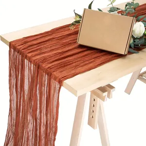 Terracotta Käsetuch-Tischläufer mit plissierter Textur auf einem Holztisch präsentiert