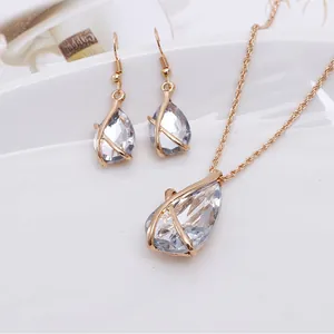 Close-up of teardrop crystal jewelry set with gold criss-cross cage detail
