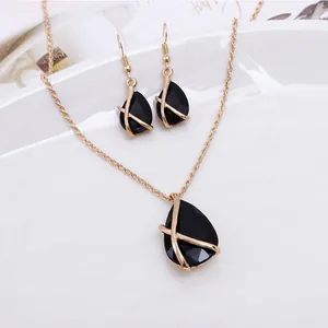 Elegant gold jewelry set featuring black waterdrop gemstones with crisscross design