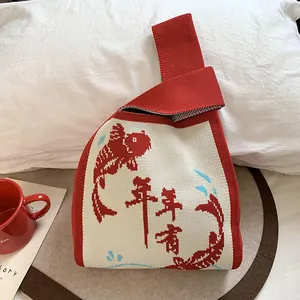 Dettaglio di una borsa da polso rossa in maglia con motivo tradizionale di carpe koi