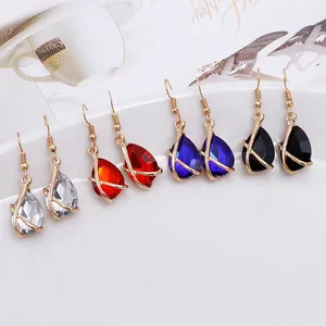 Detail of elegant teardrop gemstone earrings in red, blue, black, and clear colors.