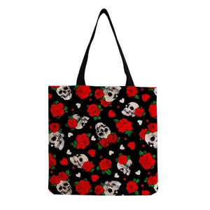 Detailed view of skull and red rose printed tote bag on black background fabric.