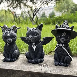 Detailed view of three gothic black cat figurines with horns, wings, and wizard hats.