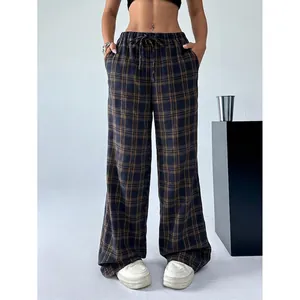 Detail einer karierten Hose mit weitem Bein, hoher Taille und verstellbarem Kordelzug.