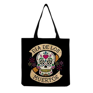Detail view of a black canvas tote bag with a colorful sugar skull and Dia de los Muertos print