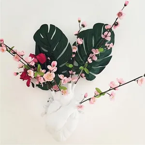 Detailed view of a white anatomical heart-shaped resin vase with pink floral arrangement