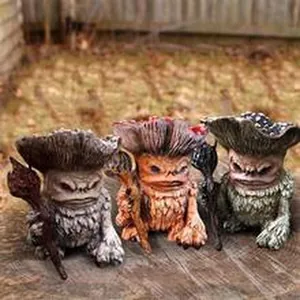 Macro detail view of three unique resin mushroom monster figurines on a wooden surface.