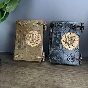 Detailed view of two ornate vintage resin magic books in gold and black finishes