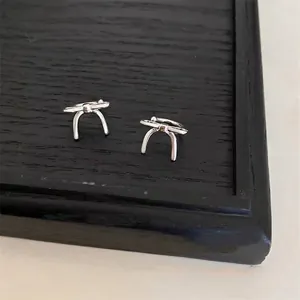 Elegant silver bow-knot ear clips for non-pierced ears on black background